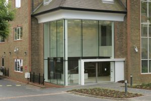 A complete Frameless Structural glazing system on a corner of a building covering the entrance and stairwell