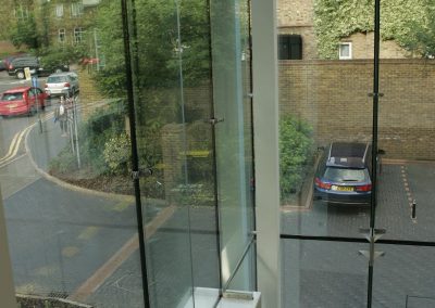 A complete Frameless Structural glazing system on a corner of a building covering the entrance and stairwell